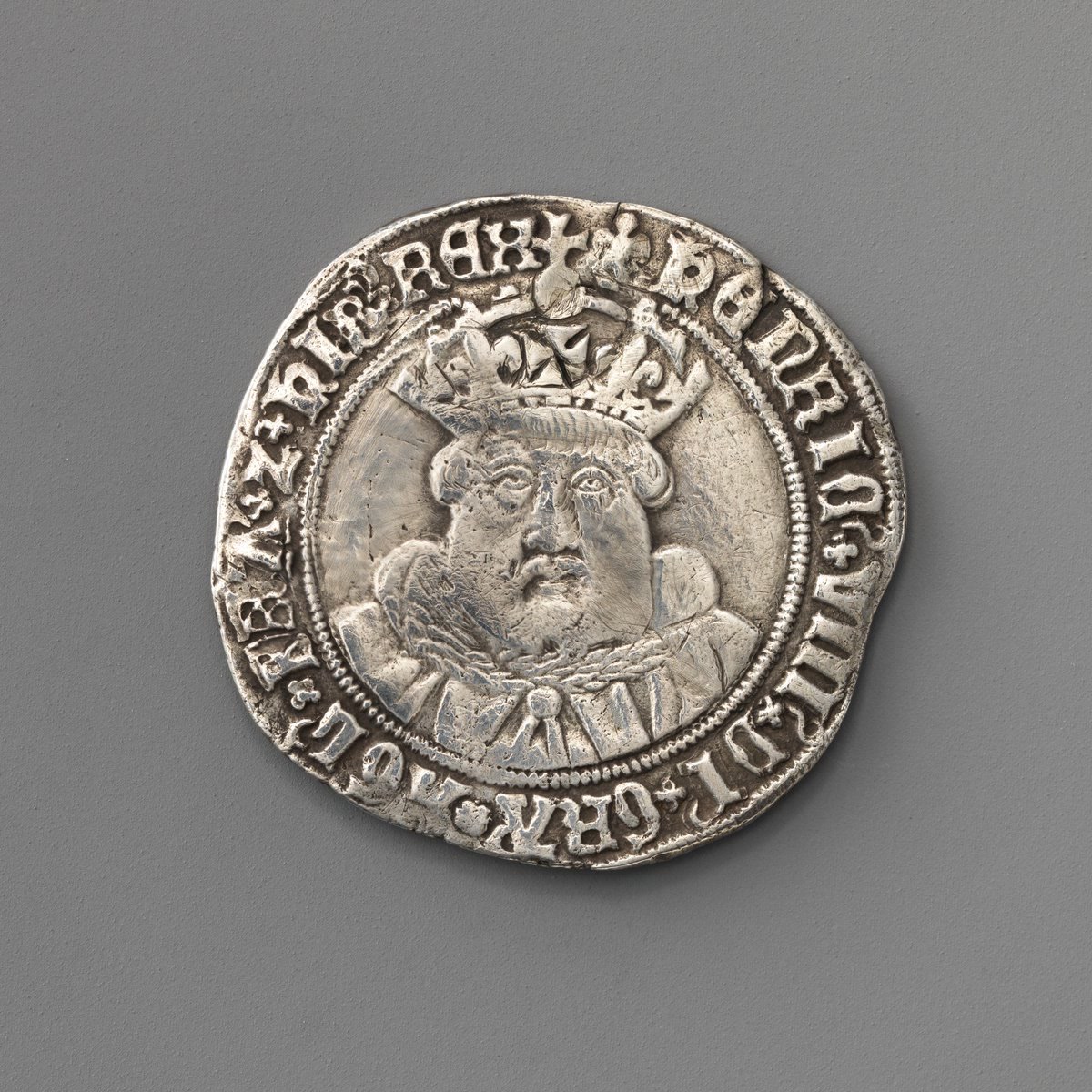 Henry VIII's debased silver shilling, the testoon, with a crowned bearded profile facing right.