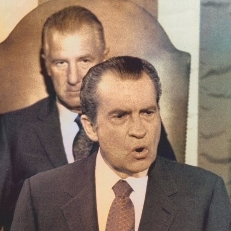 Richard Nixon at a podium addressing Congress, with Vice President Spiro Agnew seated behind him.