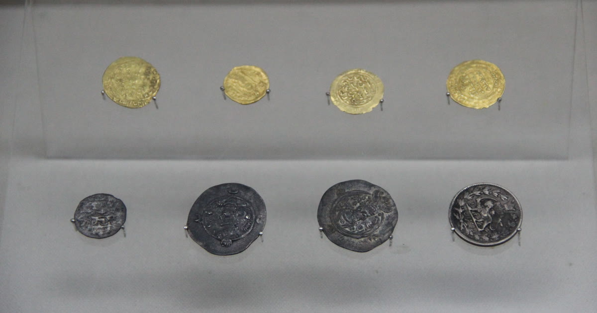 Gold and silver coins laid side by side for comparison.