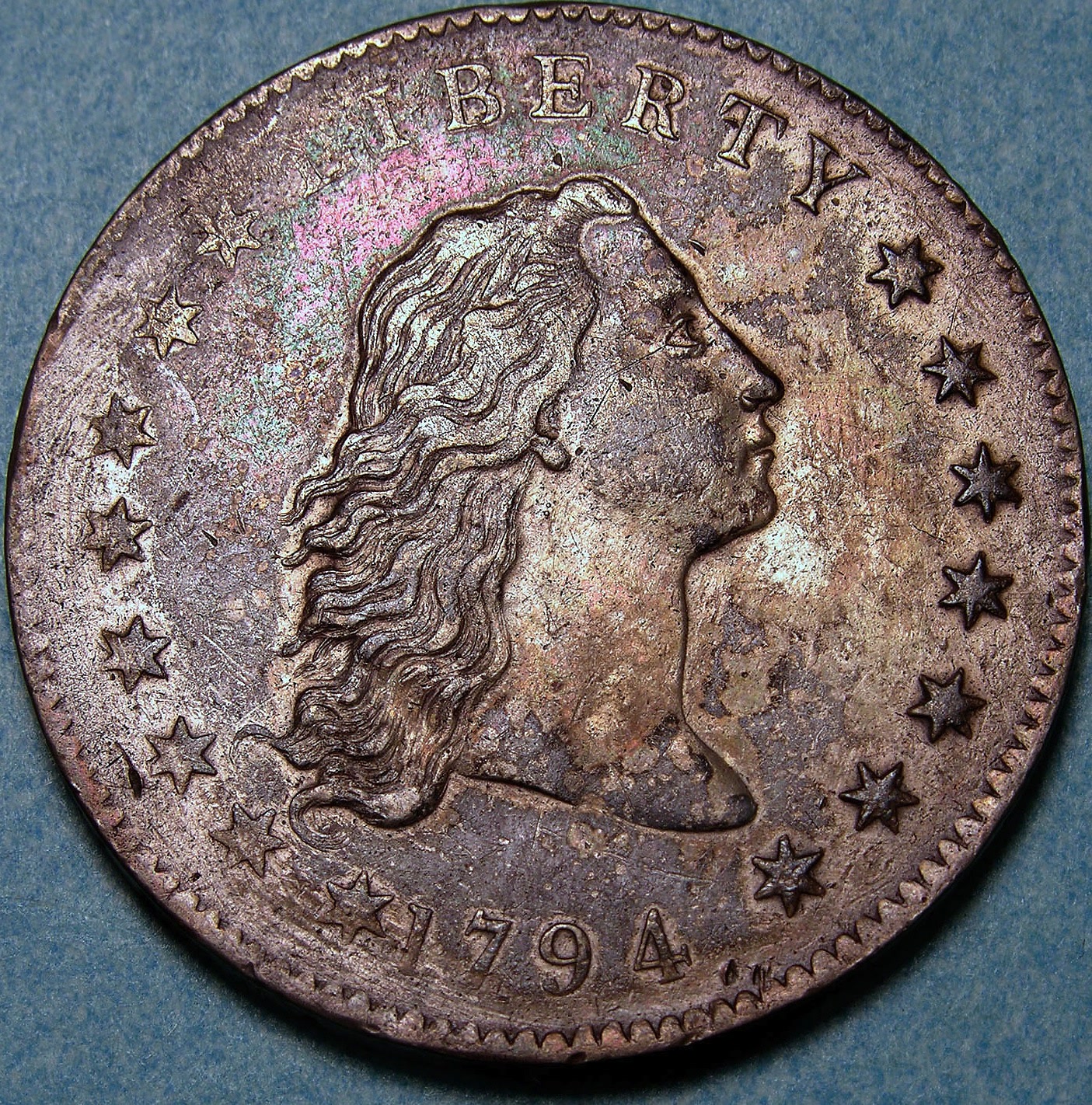 1794 Flowing Hair silver dollar, Liberty with unbound hair and the date under her neck, the first dollar the United States minted.